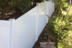 Front yard vinyl fence up a steep hill